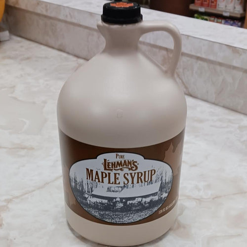 Handcrafted beige jug of amber maple syrup with vintage brown label featuring a historic sugar shack scene, made in USA, suitable for Kitchen & Food, Pantry, USA Made, Best Sellers, and Promo Eligible collections.