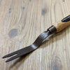 Handcrafted grubber weeding tool featuring a powder-coated, hammer-finished steel fork and smooth natural wood handle with leather loop, ideal for farm, garden, and lawncare use.