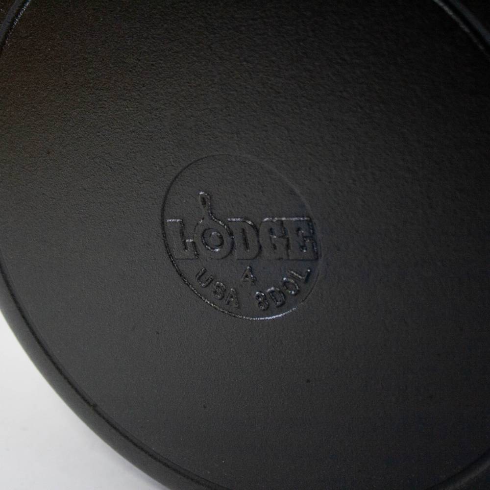 Close-up of the bottom of a handcrafted cast iron cookware piece embossed with the Lodge brand and USA body, ideal for Kitchen & Food, Cookware, Cast Iron, USA Made, Best Sellers, and Promo Eligible collections.