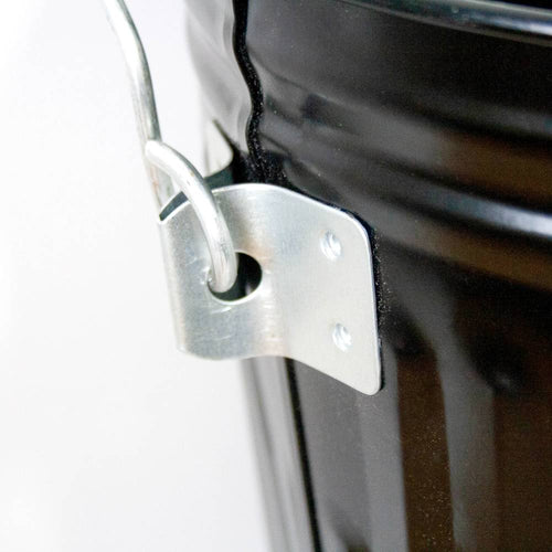 Close-up of the sturdy metal bail handle attached with rivets to a black painted steel ash pail, handcrafted for use in stoves and hearth accessories collections.