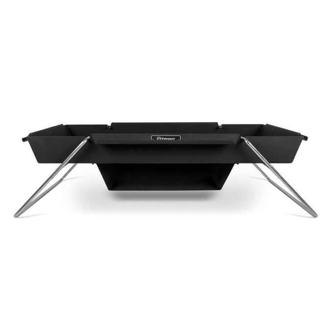 Black steel portable fire pit with angled stainless steel legs and an attached baking compartment, designed for versatile outdoor cooking in camping and garden settings.