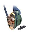 Green ergonomic firewood carrier loaded with split logs, worn on the upper arm with a padded strap, designed to distribute weight evenly; shown with a black flashlight nearby.