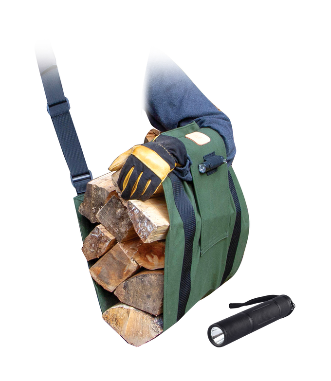 Green ergonomic firewood carrier loaded with split logs, worn on the upper arm with a padded strap, designed to distribute weight evenly; shown with a black flashlight nearby.