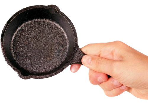 Hand holding a pre-seasoned mini cast iron skillet with textured cooking surface and small handle, ideal for kitchen gadgets and cast iron cookware collections.
