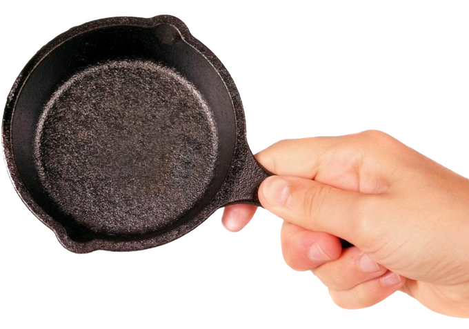 Hand holding a pre-seasoned mini cast iron skillet with textured cooking surface and small handle, ideal for kitchen gadgets and cast iron cookware collections.