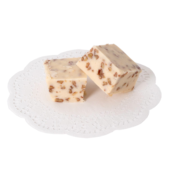 Two pieces of handcrafted creamy white fudge with pecan pieces, presented on a delicate lace paper doily, part of Kitchen & Food, Snacks and Sweets, USA Made, and Best Sellers collections.