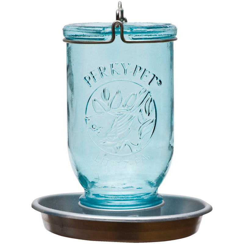 Antique-style blue glass mason jar with embossed bird design, resting on a galvanized metal base with perch, handcrafted for garden and animal care enthusiasts.