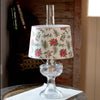 Shatterproof parchment lamp shade decorated with pine sprigs, poinsettias, and holly, designed to soften light for smaller Aladdin lamps, featured in Lamps & Lighting and Lamp Shades collections.