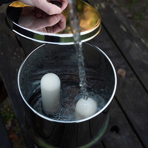 Handcrafted stainless steel gravity water filter chamber being filled with water, featuring white Ultra Fluoride ceramic filter elements, perfect for Farm, Garden & Tool and Water Treatment collections.