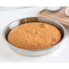 Lightweight 9-inch stainless steel round cake pan with an evenly baked golden brown cake, designed for durability and efficient heat transfer in baking cookware collections.