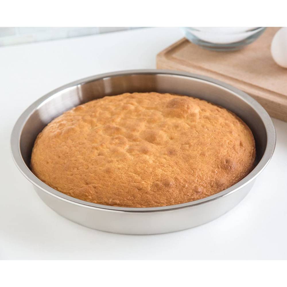 Lightweight 9-inch stainless steel round cake pan with an evenly baked golden brown cake, designed for durability and efficient heat transfer in baking cookware collections.