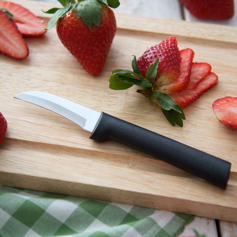 Handcrafted paring knife with high carbon surgical stainless steel curved blade and solid black handle on wooden cutting board with sliced fresh strawberries, made in USA, ideal for Farm, Garden & Tool and Kitchen & Food collections.