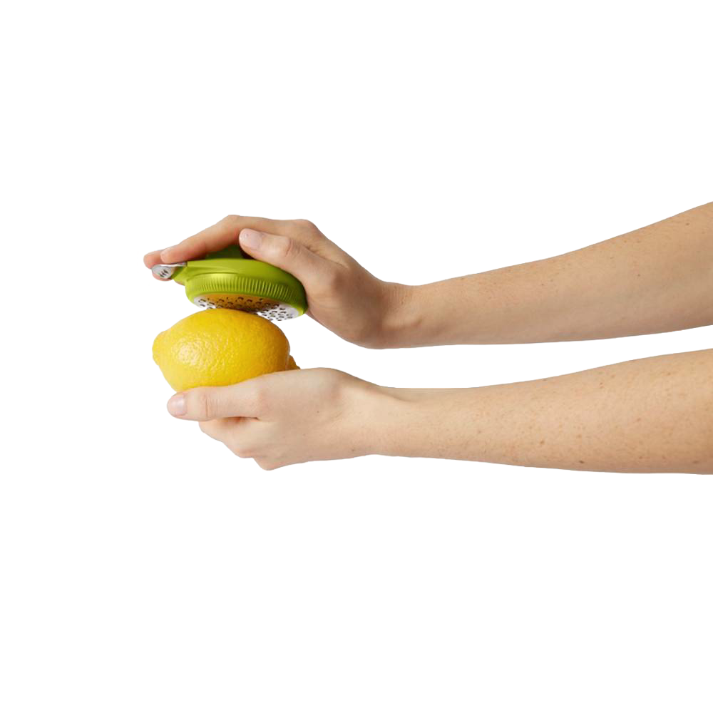 Person holding a green ergonomic citrus zester over a lemon, demonstrating easy zesting for Kitchen & Food, Kitchen Gadgets, Cooking and Baking Helpers, and Best Sellers collections.