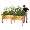 Man watering a handcrafted wooden elevated garden bed filled with lush vegetable plants, ideal for space-saving planting in Farm, Garden & Tool and Best Sellers collections.
