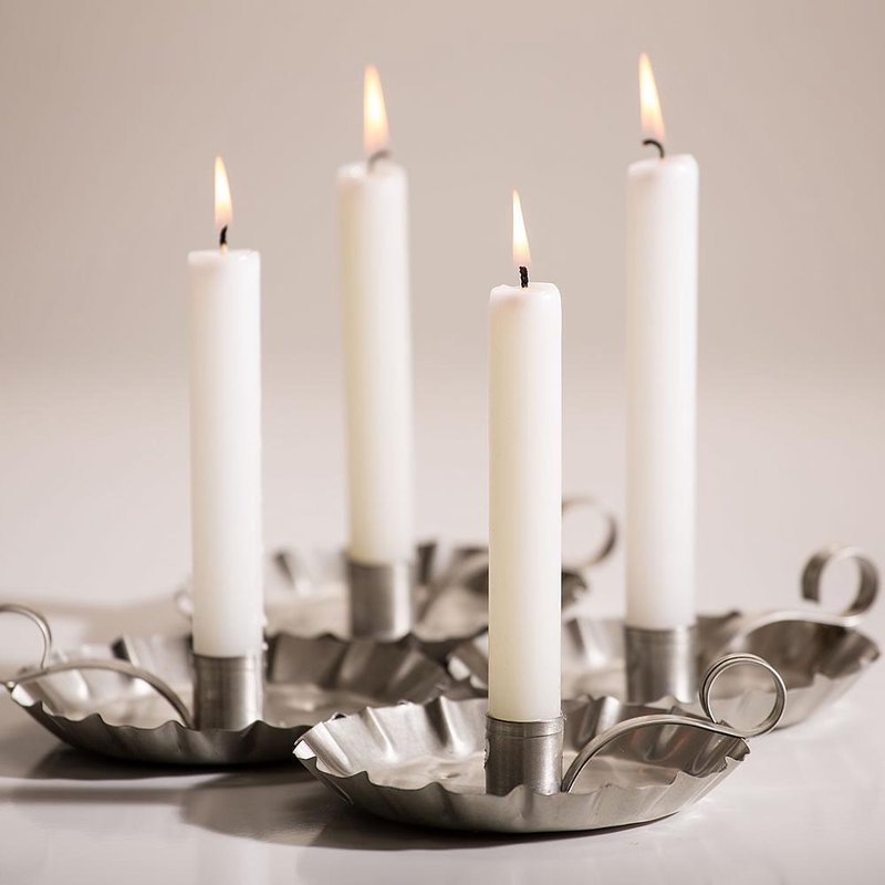 Four lit handcrafted white taper candles with sturdy thick wicks set in rustic metal holders, showcasing bright, dripless flames, part of USA Made, Lamps & Lighting, and Emergency Supplies collections.