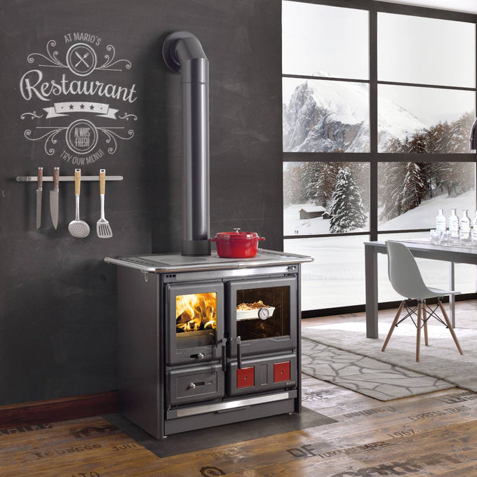 Steel wood-burning cook stove with polished cooking surface, dual glass doors showing fire and oven, removable ash drawer, and cast iron hearth, featured in Stoves and Cookstoves collections.