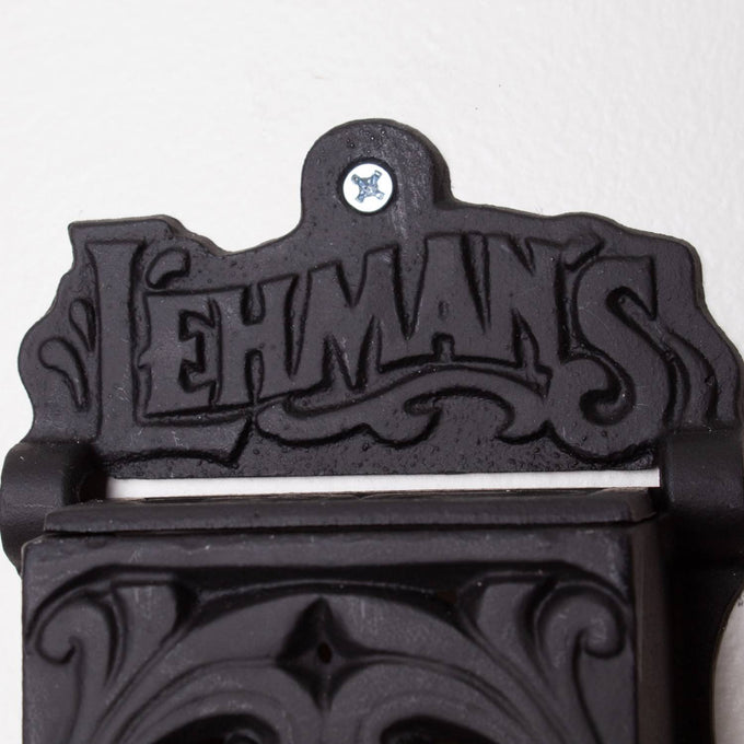 Close-up of a handcrafted black cast iron wall-mounted matchbox holder featuring embossed Lehman's logo and vintage ornamental design, Amish made in USA, ideal for Home & Decor and Household Helpers collections.