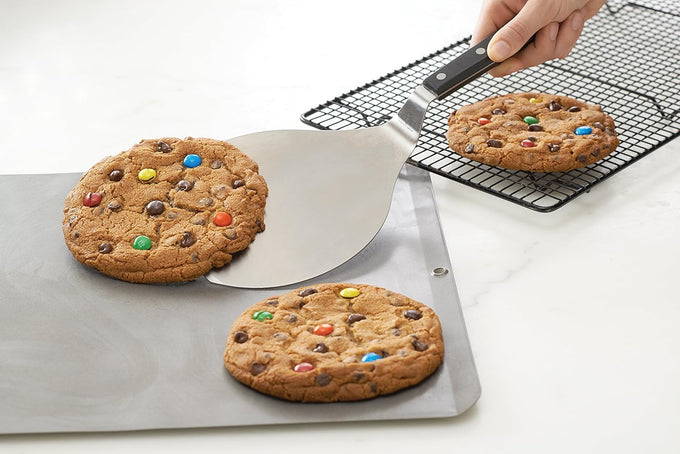 Wide stainless steel spatula with triple-riveted angled handle lifting a freshly baked cookie, designed for easy serving and sliding under baked goods, ideal for Kitchen & Food, Kitchen Gadgets, Storage and Serving, Best Sellers, Promo Eligible collections.