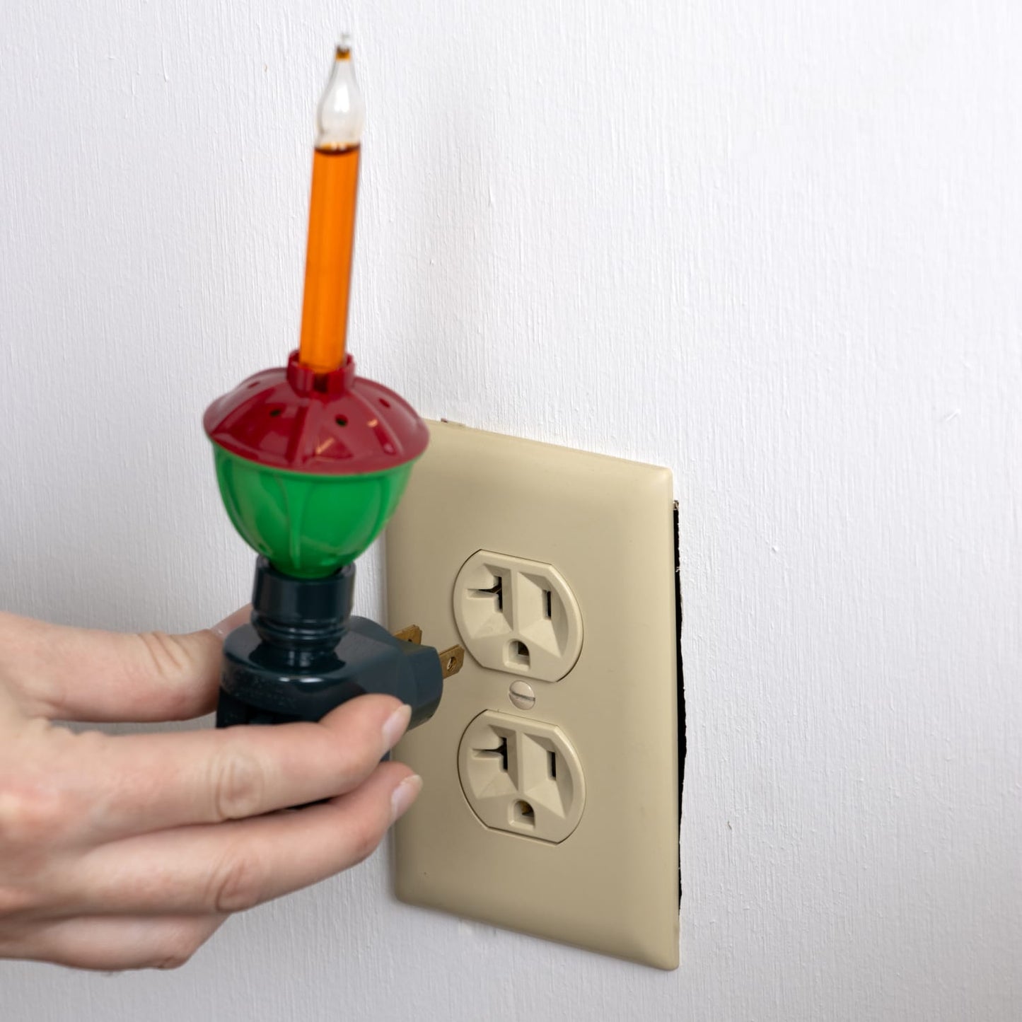 Handcrafted classic bubble light nightlight with green and red porcelain base, being plugged into a wall outlet, ideal for Home & Decor, Holiday Decor, Best Sellers, and Promo Eligible collections.