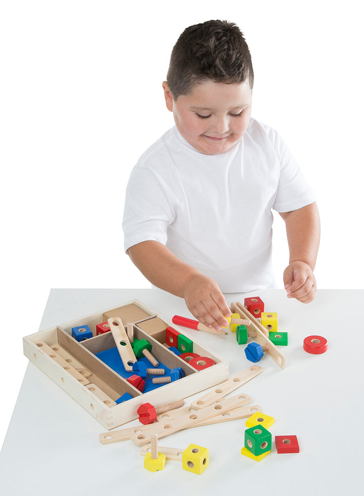 Young child playing with a wooden construction building set featuring colorful blocks, nuts, bolts, and connecting bars, designed for indoor play in toys and games collections.
