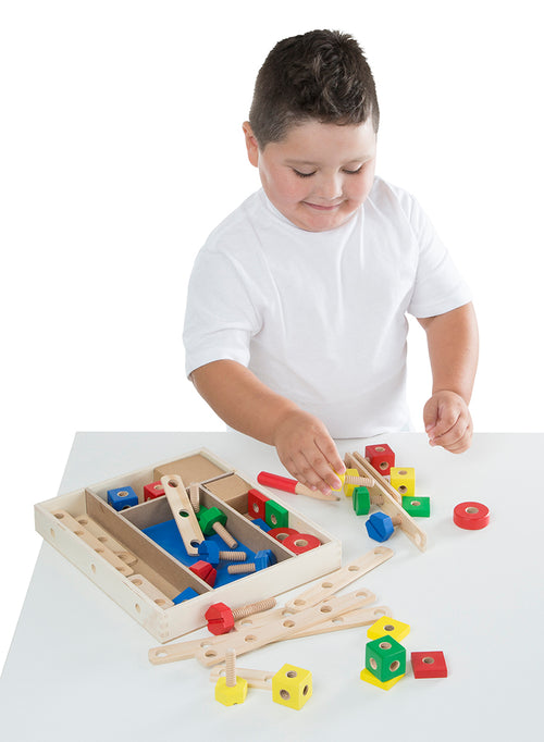 Young child playing with a wooden construction building set featuring colorful blocks, nuts, bolts, and connecting bars, designed for indoor play in toys and games collections.