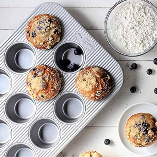 Handcrafted non-stick muffin pan with 12 fluted cups for even baking, made in USA, shown with freshly baked blueberry muffins and baking ingredients, ideal for Kitchen & Food and Baking Supplies collections.