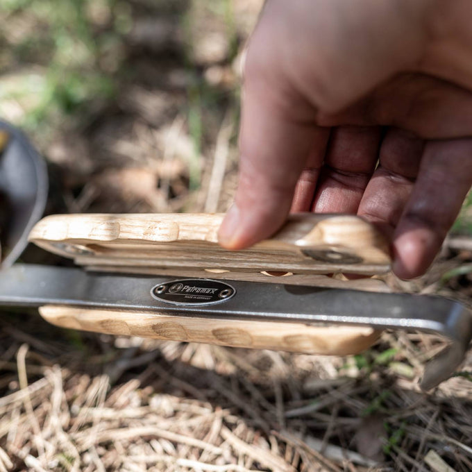 Handheld wooden handle with ergonomic grooves for secure grip attached to wrought iron pan, featured in Farm, Garden & Tool, Kitchen & Food, Camping, Cookware, and Pots and Pans collections.