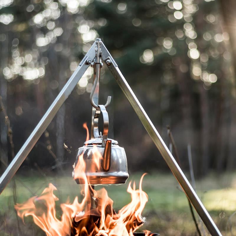 Stainless steel kettle hanging from a tripod over an open campfire flame, designed for outdoor use in Farm, Garden & Tool, Kitchen & Food, Camping, Brewing Coffee and Tea, Best Sellers, and Promo Eligible collections.