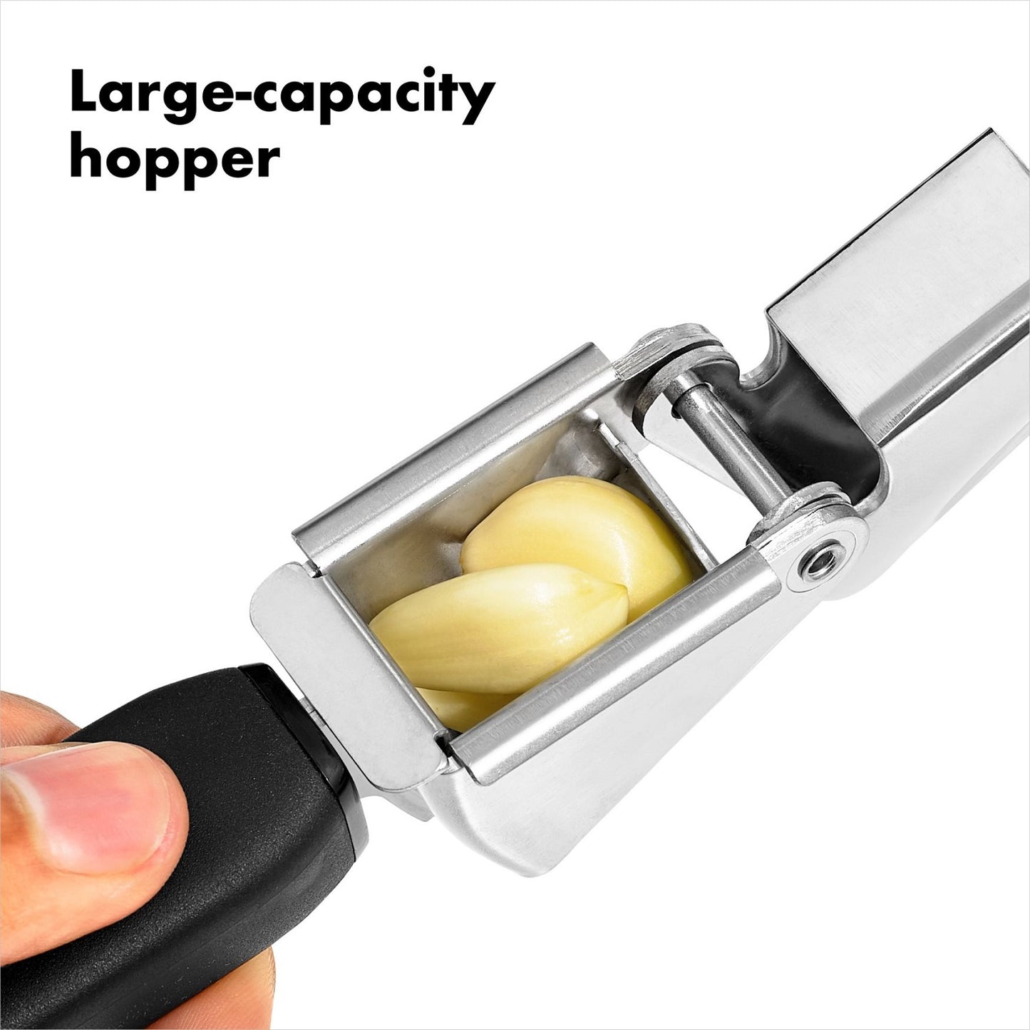 Close-up of a garlic press with a large stainless steel hopper filled with garlic cloves and a black non-slip handle, designed for comfortable use in kitchen gadgets and cooking helpers collections.