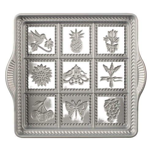 Cast aluminum baking pan with decorative embossed designs including bird, pineapple, flower, and butterfly, featuring rope borders, handcrafted in USA, ideal for kitchen and baking supplies collections.