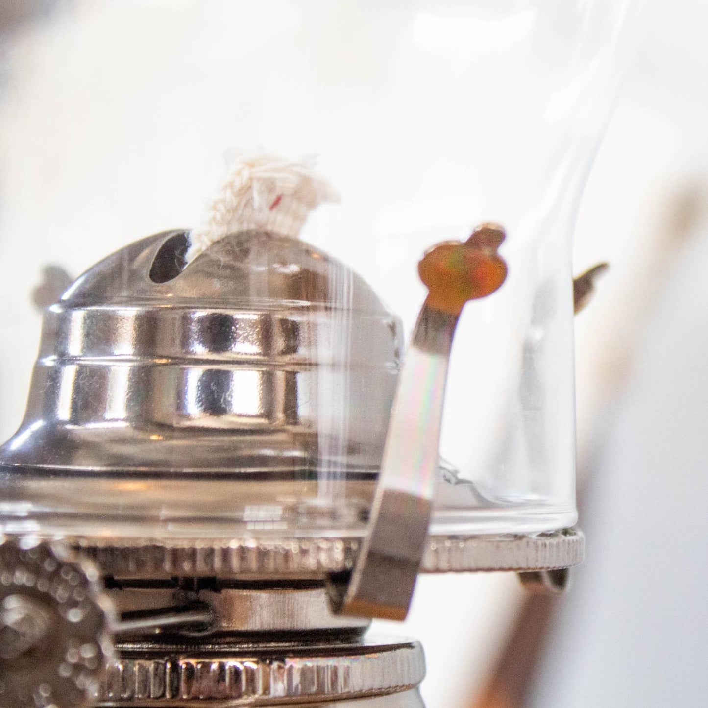 Close-up of a handcrafted metal oil lamp burner with wick, featuring a glass chimney and lever, designed for lamps and lighting, oil lamps, and table lamps collections.