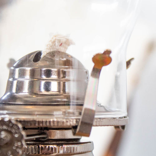 Close-up of a handcrafted metal oil lamp burner with wick, featuring a glass chimney and lever, designed for lamps and lighting, oil lamps, and table lamps collections.