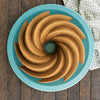 Bundt cake with a classic swirl pattern displayed on a turquoise plate, perfect for showcasing elegant desserts in Kitchen & Food, Cookware, Baking Supplies, USA Made, and Best Sellers collections.