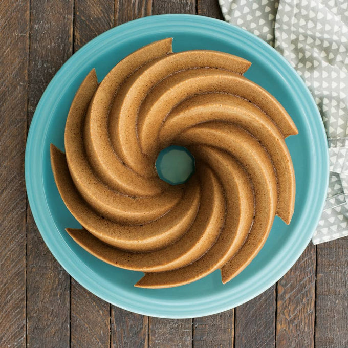 Bundt cake with a classic swirl pattern displayed on a turquoise plate, perfect for showcasing elegant desserts in Kitchen & Food, Cookware, Baking Supplies, USA Made, and Best Sellers collections.