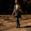 Person walking along a dry orchard path carrying a weather- and water-resistant charcoal gray harvesting bag with convertible straps, ideal for Farm, Garden & Tool and Apple Harvest Supplies collections.