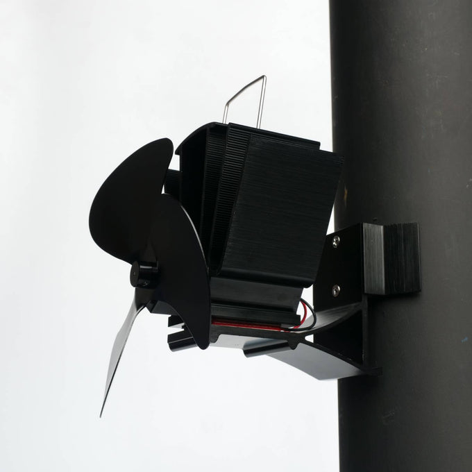 Black heat-powered magnetic fan with three broad blades attached to a vertical stove flue pipe, designed to enhance warm air circulation in Stoves, Hearth Accessories, Best Sellers, and Promo Eligible collections.