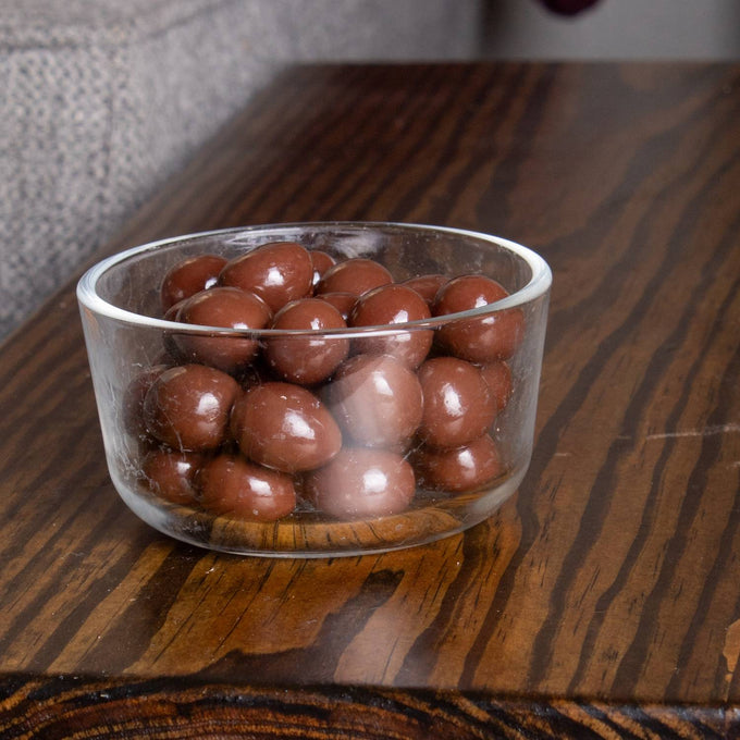 Clear glass bowl filled with handcrafted sugar-free milk chocolate covered peanuts, showcasing smooth glossy chocolate coating, perfect for Kitchen & Food and Snacks collections.