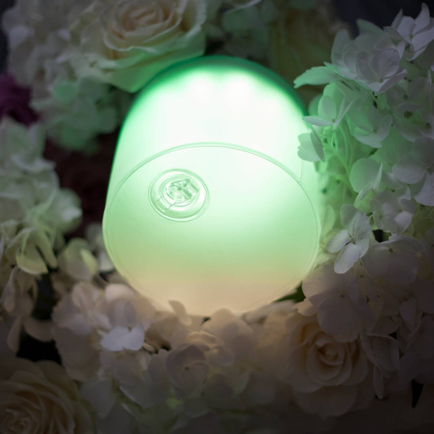 Soft green glowing inflatable LED solar light nestled among white and cream flowers, offering unique, eco-friendly illumination for Farm, Garden & Tool and Lamps & Lighting collections.