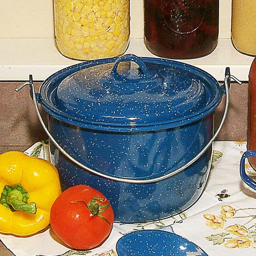 Royal Blue enamelware kettle with white speckled pattern and lid, featuring a sturdy metal handle, displayed alongside fresh vegetables on a kitchen counter, part of Farm, Garden & Tool and Kitchen & Food collections.