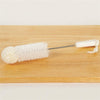 Cleaning brush with white foam tip, twisted wire handle, and a white plastic grip with hanging loop, suitable for household cleaning and USA made collections
