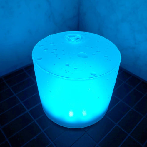 Handcrafted Luci Color Essence solar light glowing in a vibrant blue hue with water droplets on top, perfect for eco-friendly use in camping, farm, garden, and emergency supplies collections.