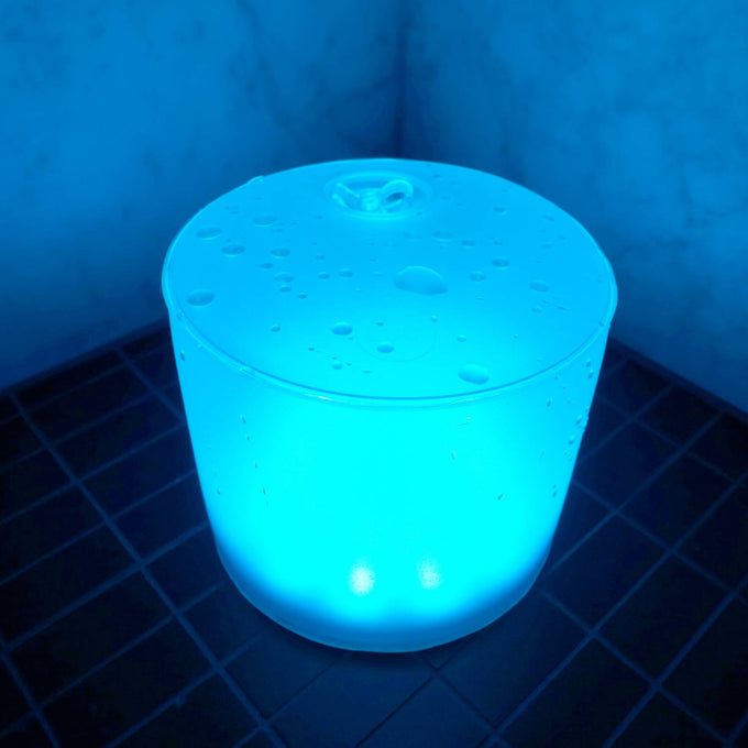 Handcrafted Luci Color Essence solar light glowing in a vibrant blue hue with water droplets on top, perfect for eco-friendly use in camping, farm, garden, and emergency supplies collections.