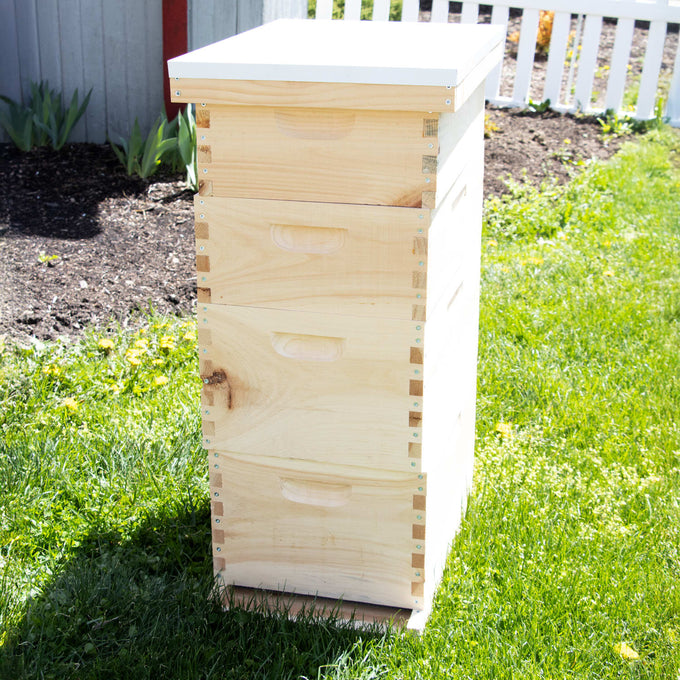 Handcrafted Amish-made 8-frame wooden beehive kit with multiple stacked boxes and white telescoping cover, set on green lawn, suitable for beekeeping, farm, and garden use.