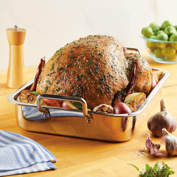 Stainless steel roasting pan with sturdy handles holding a golden herb-roasted whole chicken surrounded by vegetables, featured in Kitchen & Food, Cookware, Pots and Pans, Best Sellers, and Promo Eligible collections.