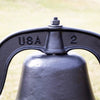 Close-up of a black cast aluminum farm bell with stamped "USA" marking, showcasing handcrafted Amish-made quality for Home & Decor, Farm, Garden & Tool, and USA Made collections.