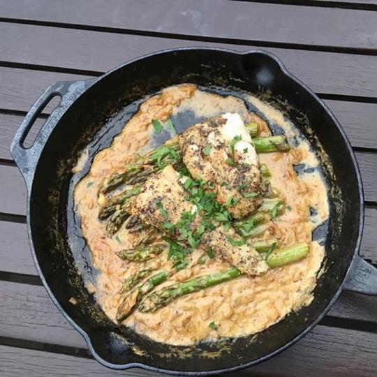 Cast iron skillet with a long handle cooking seasoned chicken breast and asparagus in a creamy sauce, suitable for Farm, Garden & Tool, Kitchen & Food, Camping, Cookware, Cast Iron, Best Sellers, and Promo Eligible collections.