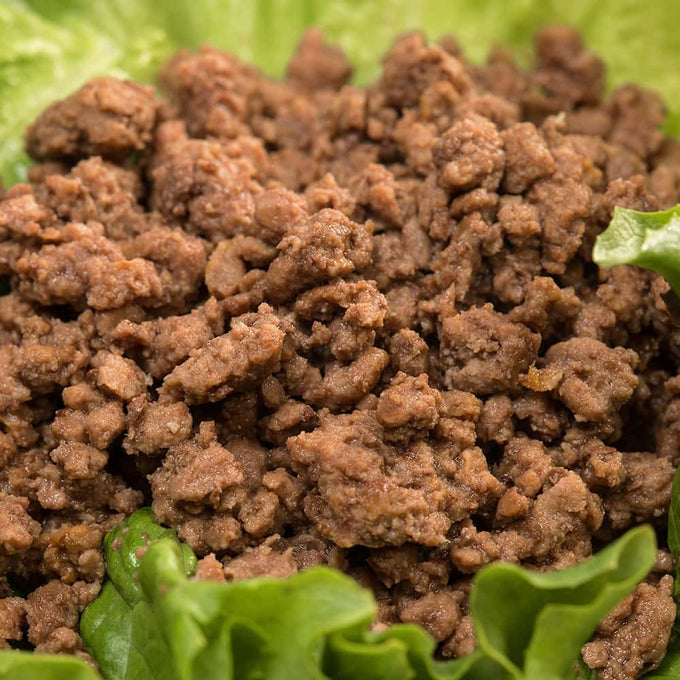 Close-up of Amish made cooked ground beef chunks resting on fresh green lettuce, highlighting handcrafted quality ideal for quick meals in Kitchen & Food, Food, Meats, Best Sellers, and Promo Eligible collections.