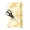 Partially unrolled beeswax food wrap with honeycomb pattern and printed text, accompanied by black-handled scissors, handcrafted in the USA for Kitchen & Food and Storage and Serving collections.