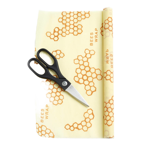Partially unrolled beeswax food wrap with honeycomb pattern and printed text, accompanied by black-handled scissors, handcrafted in the USA for Kitchen & Food and Storage and Serving collections.