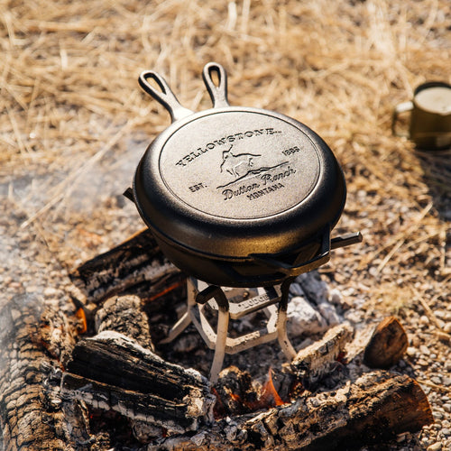 Handcrafted cast iron combo cooker with Bucking Bronco design, made in USA, shown over a wood fire outdoors, ideal for Kitchen & Food, Cast Iron, Cookware, USA Made, and Best Sellers collections.